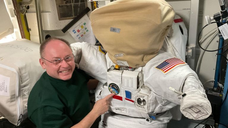 Mike Fincke next to a spacesuit. The helmet is protected to prevent scratches and contamination. Pic: NASA