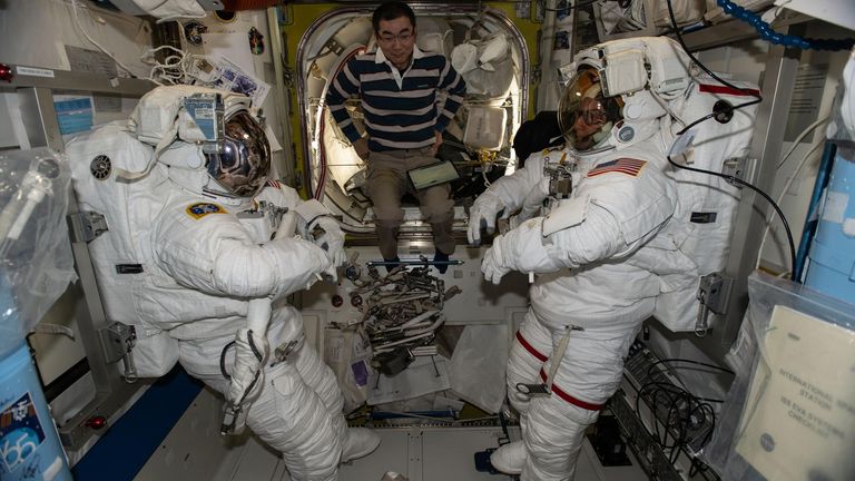 Kimiya Yui assists Zena Cardman (left) and Mike Fincke (right) during spacesuit checks ahead of the planned spacewalk. Pic: NASA