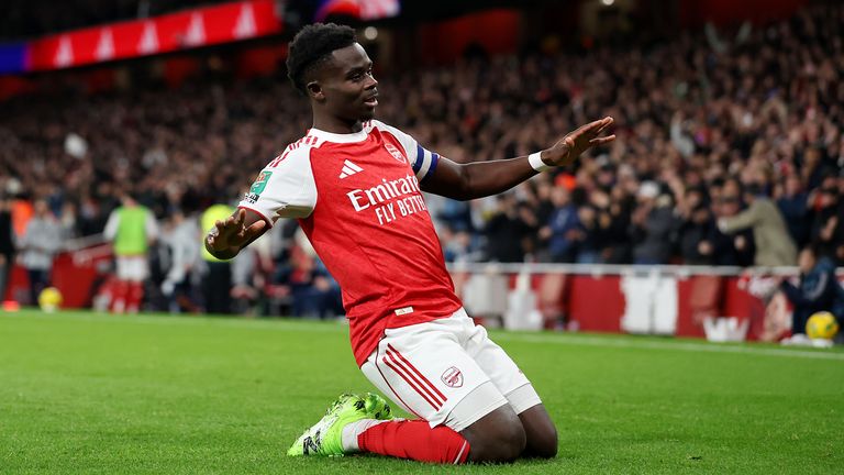 Bukayo Saka does a knee-slide celebration after scoring Arsenal's second goal against Brighton in the Carabao Cup