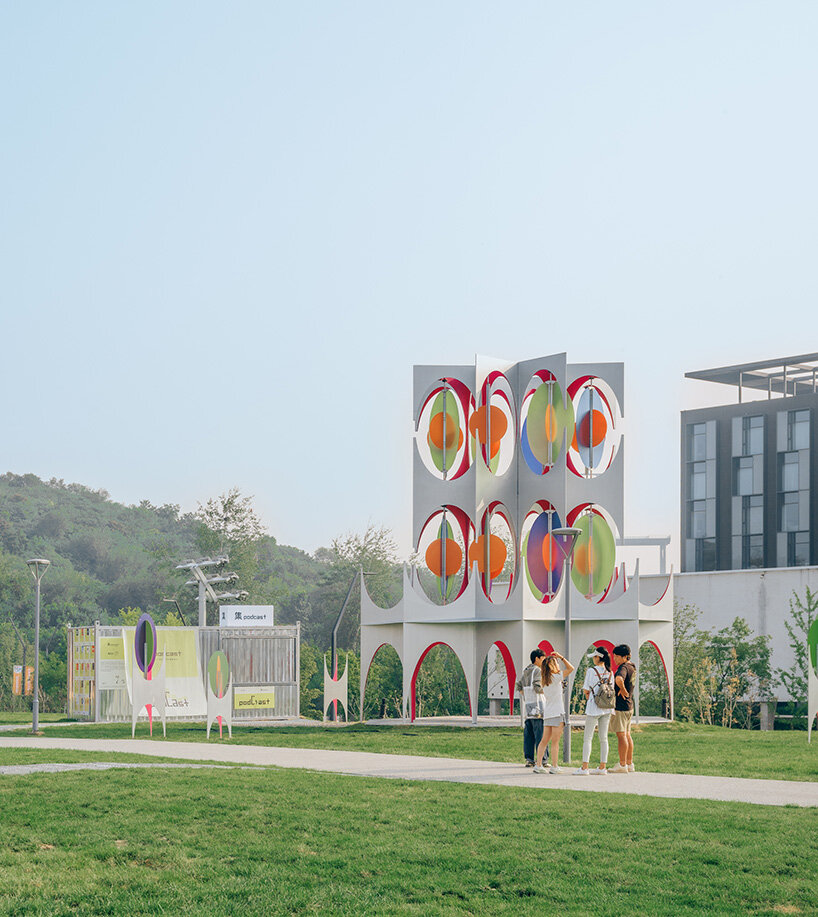 suspended colored discs move through daxing jizi design's faceted installation in beijing
