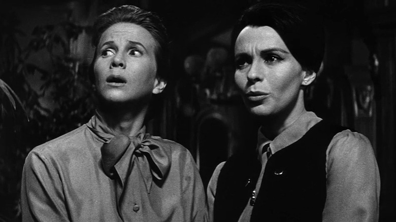 Julie Harris as Eleanor looking scared next to Claire Bloom as Theodora in The Haunting