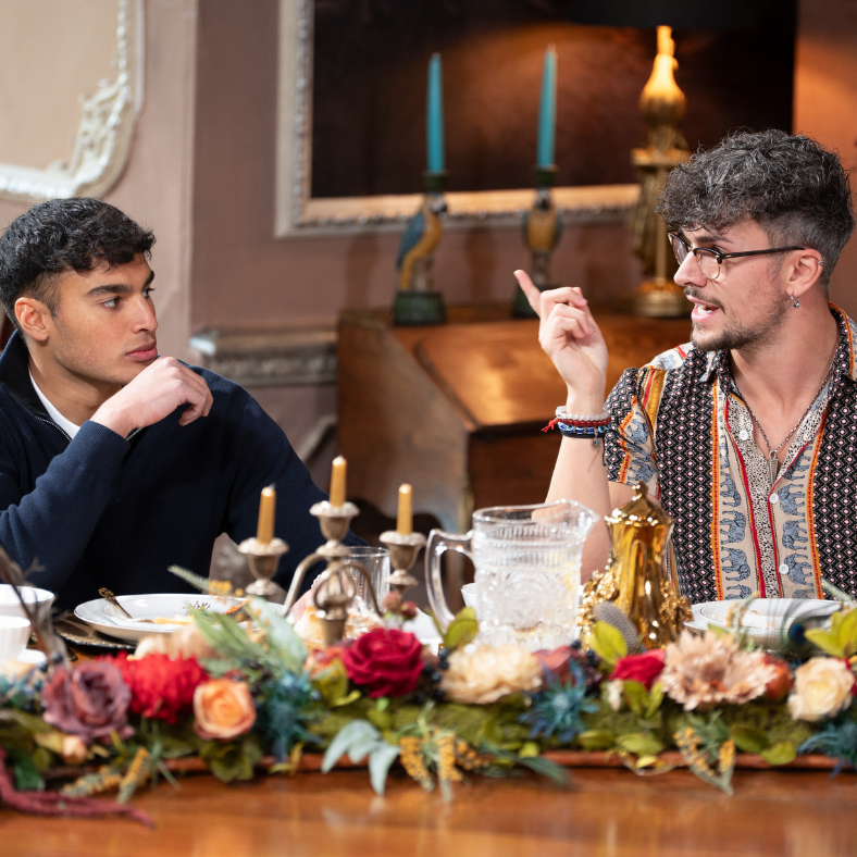 two individuals engaged in conversation at a decorated dining table