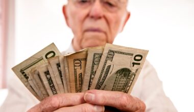 A seated person counting a fanned assortment of cash bills in their hands.
