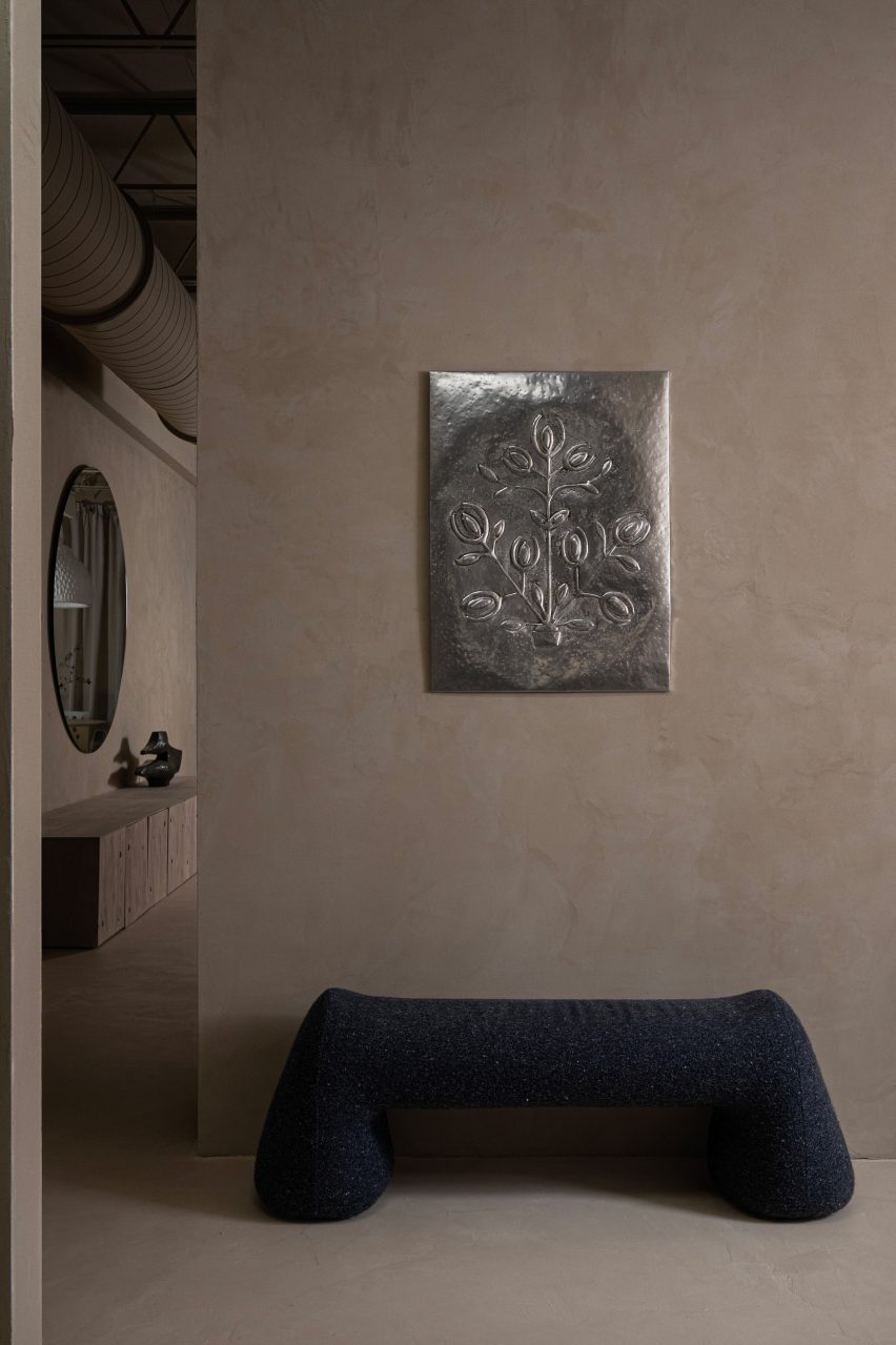 Bench by Victoria Yakusha under metal wall ornament