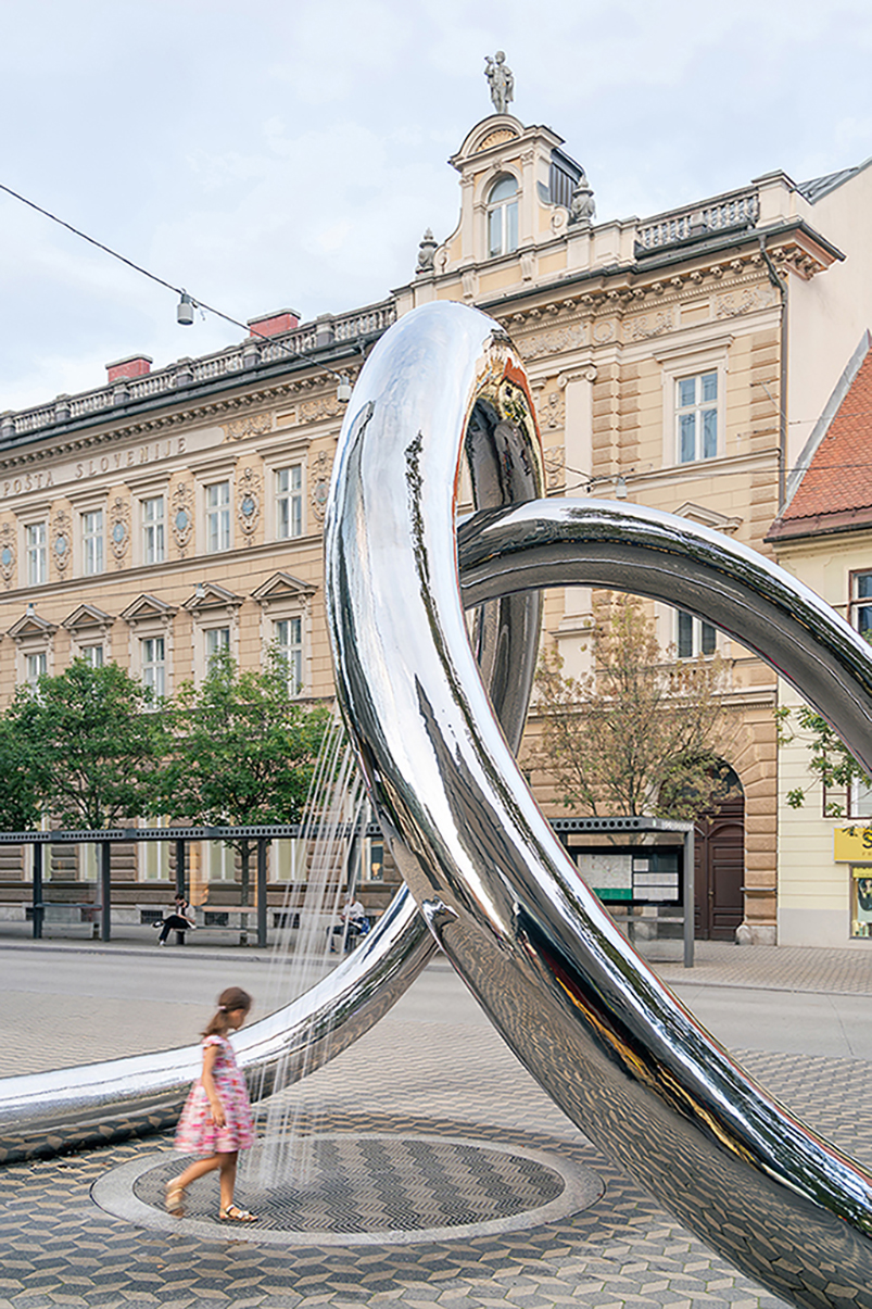 continuous steel loop forms water sculpture reflecting ljubljana’s urban fabric