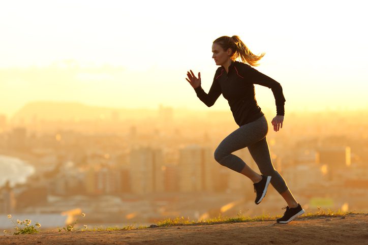 woman running fast at sunset