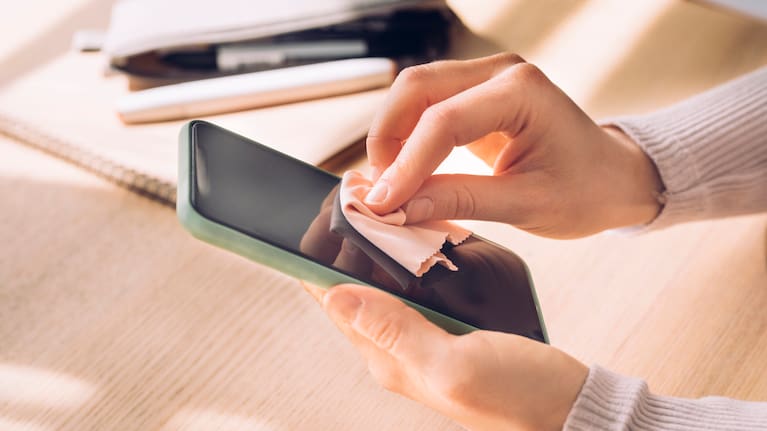 Woman Wiping the Screen of her Mobile Phone stock photo