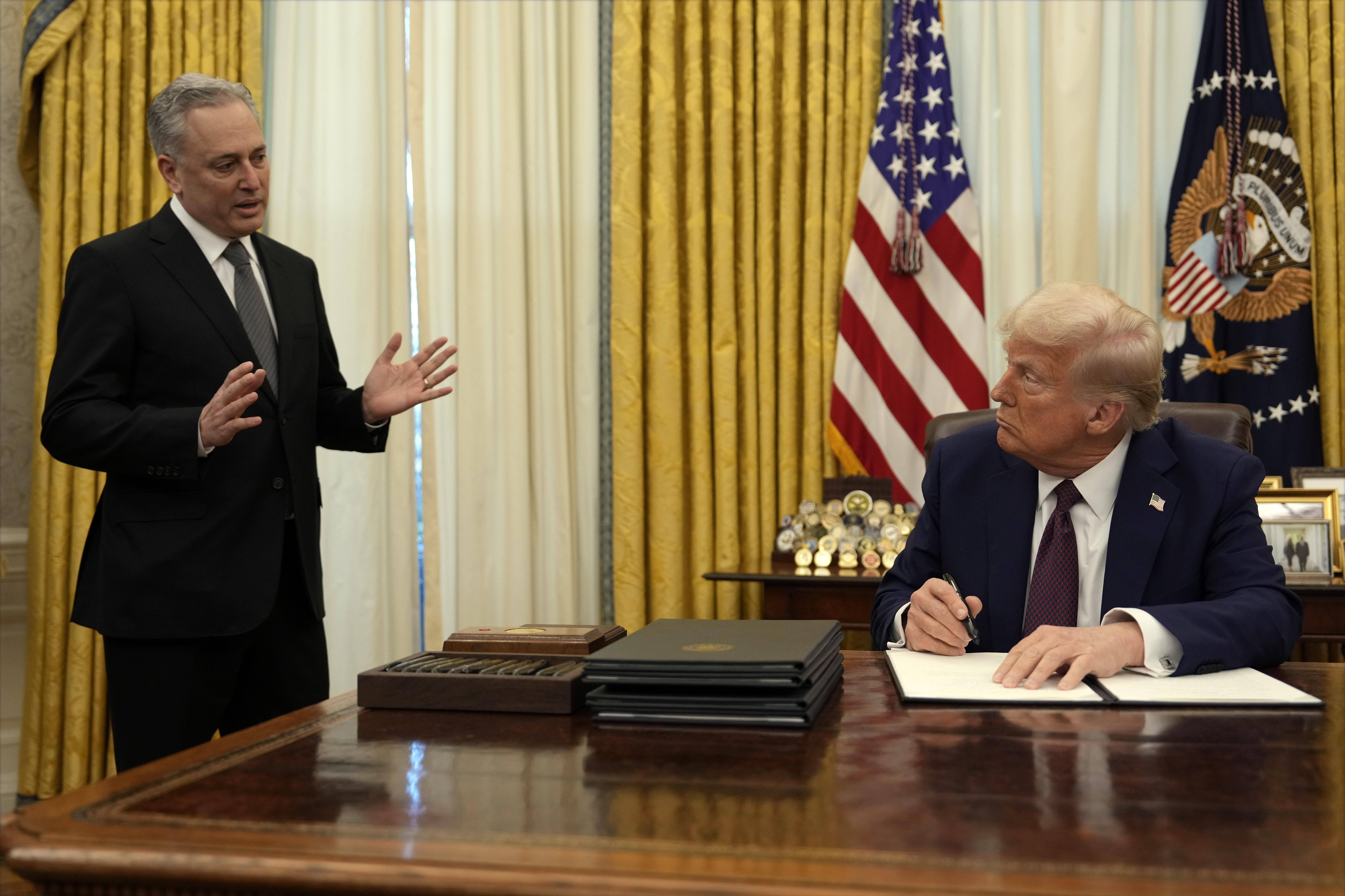 President Donald Trump listens to White House adviser David Sacks as he signs an executive order regarding cryptocurrency.