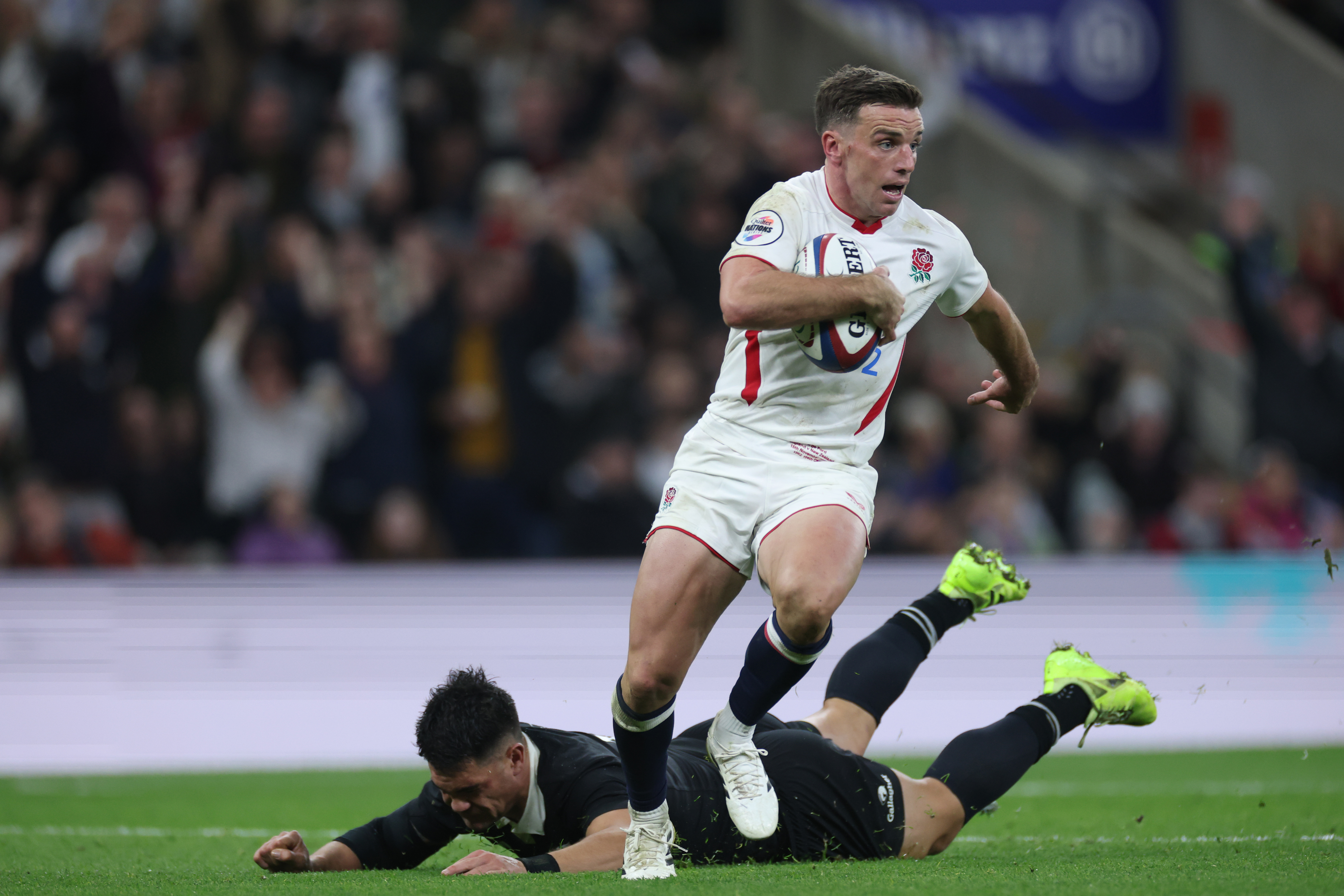 George Ford running with the ball during a rugby match.