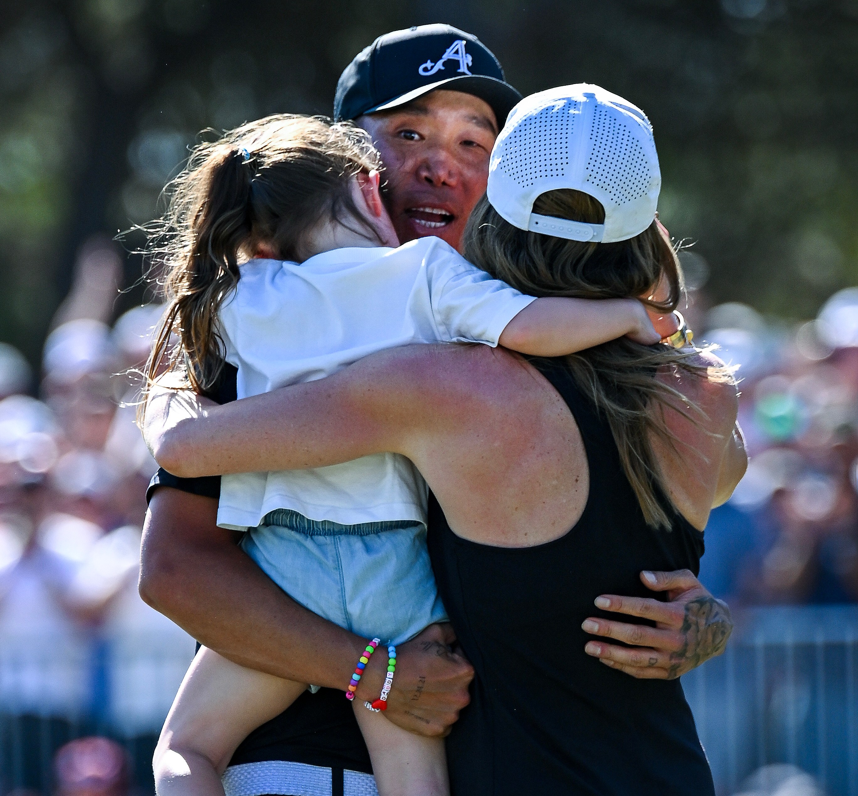 Anthony Kim of the Aces hugs his daughter and wife after winning the tournament.
