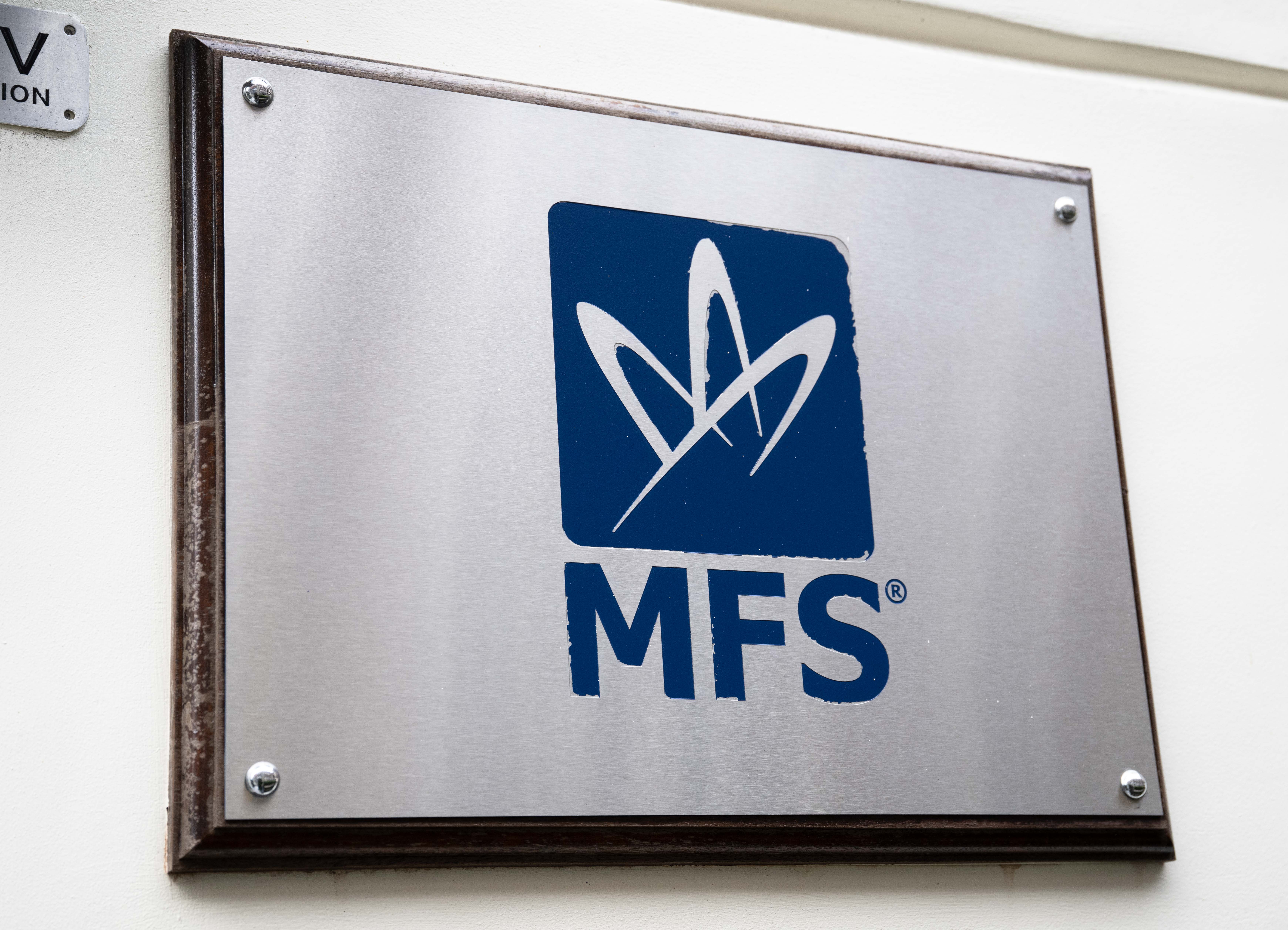 A metal sign with the Market Financial Solutions (MFS) logo, a white abstract design, and the letters MFS on a blue square.