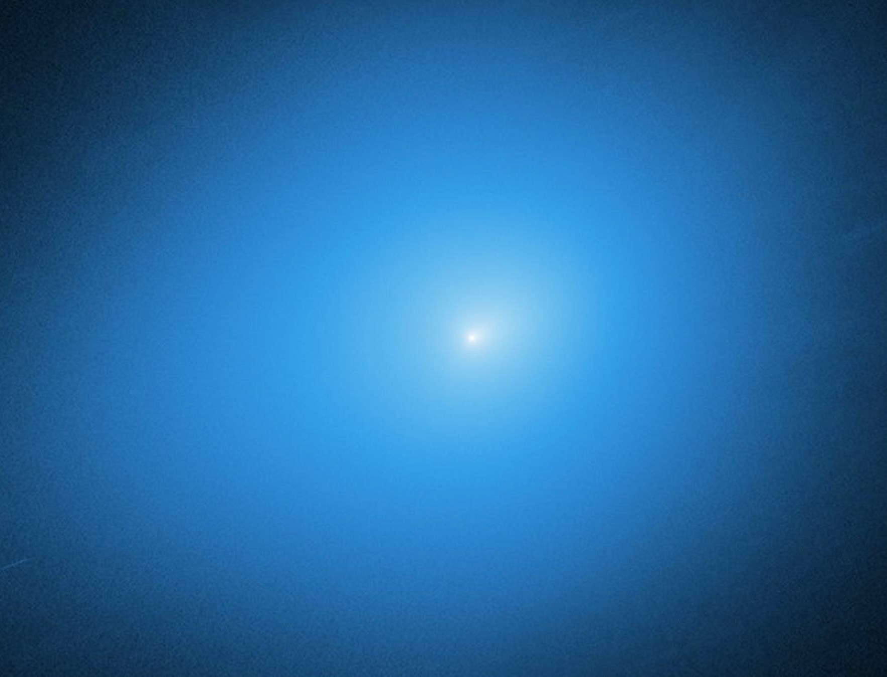 Hubble Space Telescope image of interstellar comet 3I/Atlas as a bright spot in a blue nebula.