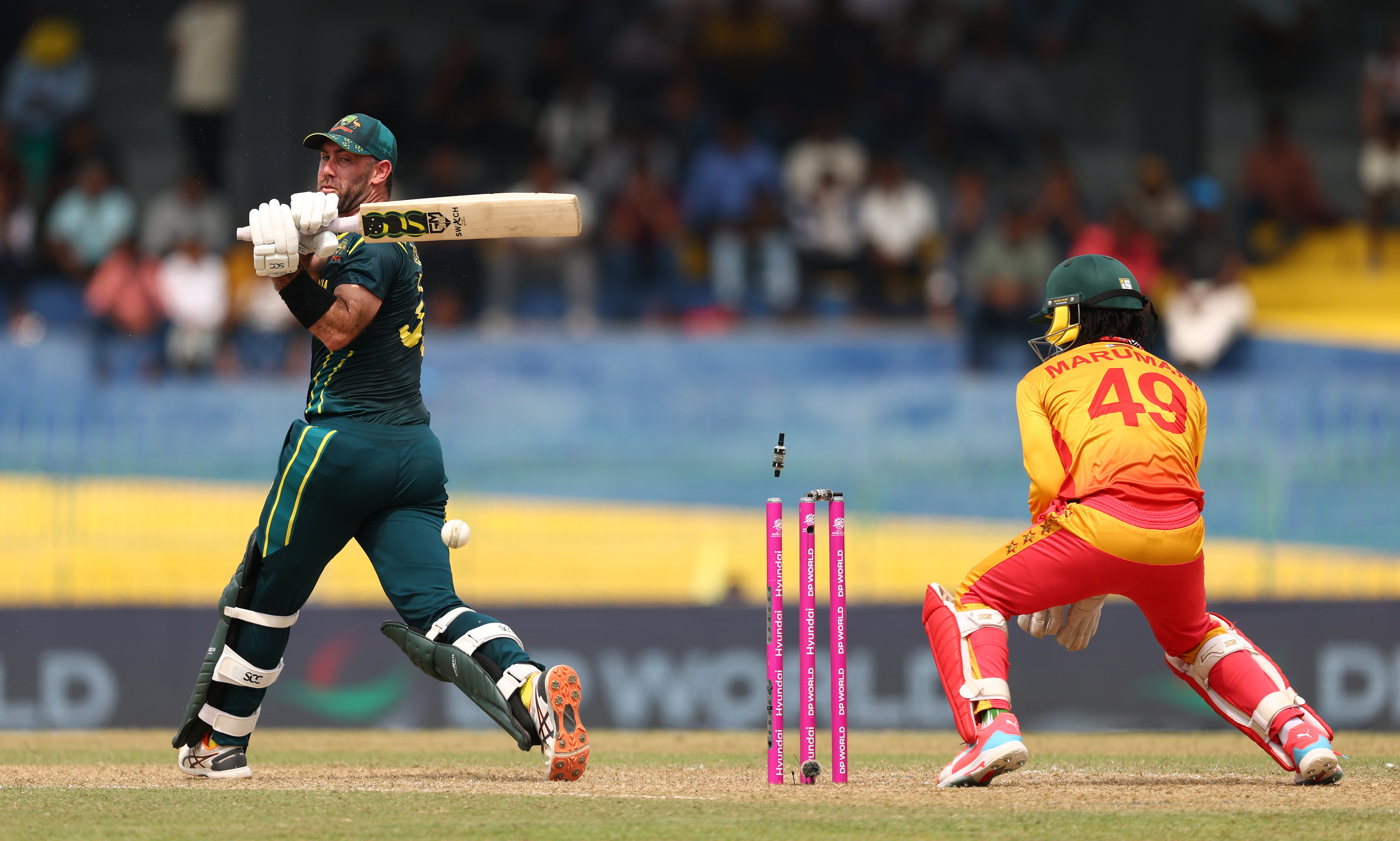 Glenn Maxwell of Australia is bowled by Ryan Burl of Zimbabwe.