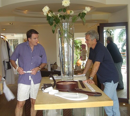 Peter Mandelson trying on a belt while Jeffrey Epstein leans on a table.