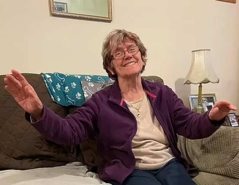 Hilda Griffiths smiling while sitting on a couch.