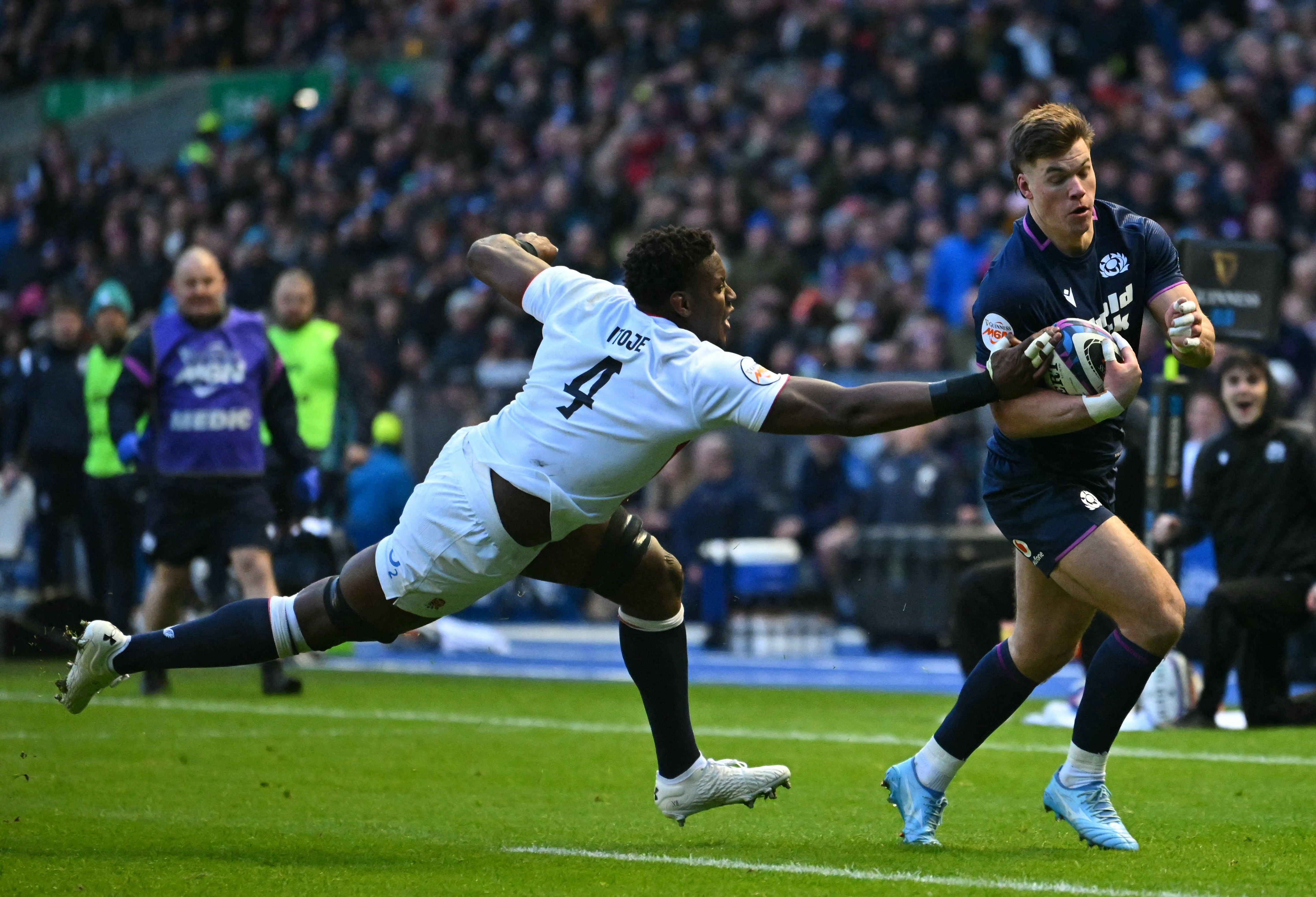 Scotland's Huw Jones scores a try against England's Maro Itoje during a Six Nations rugby match.
