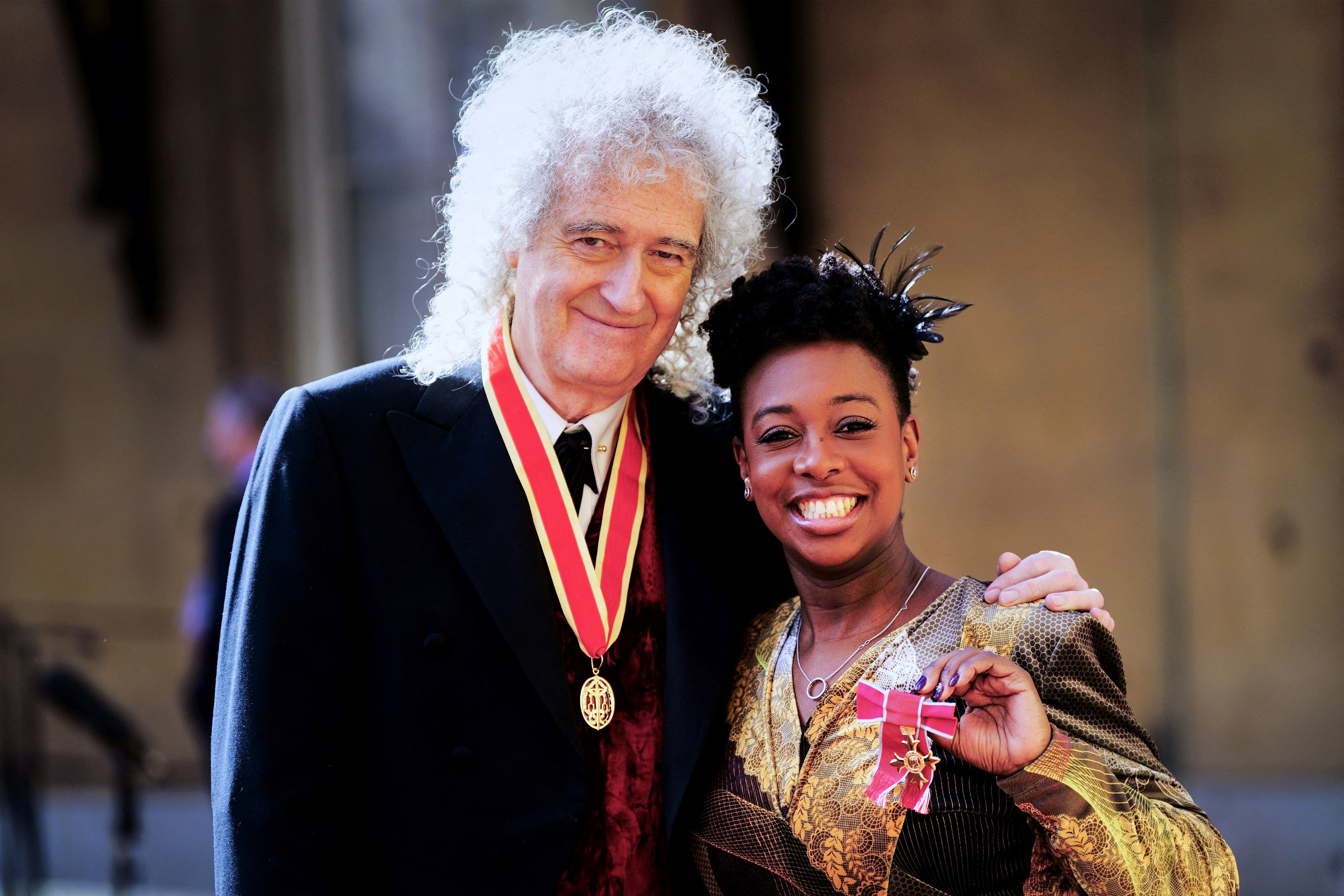 British musician Brian May and YolanDa Brown smiling with their medals after an investiture ceremony at Buckingham Palace.