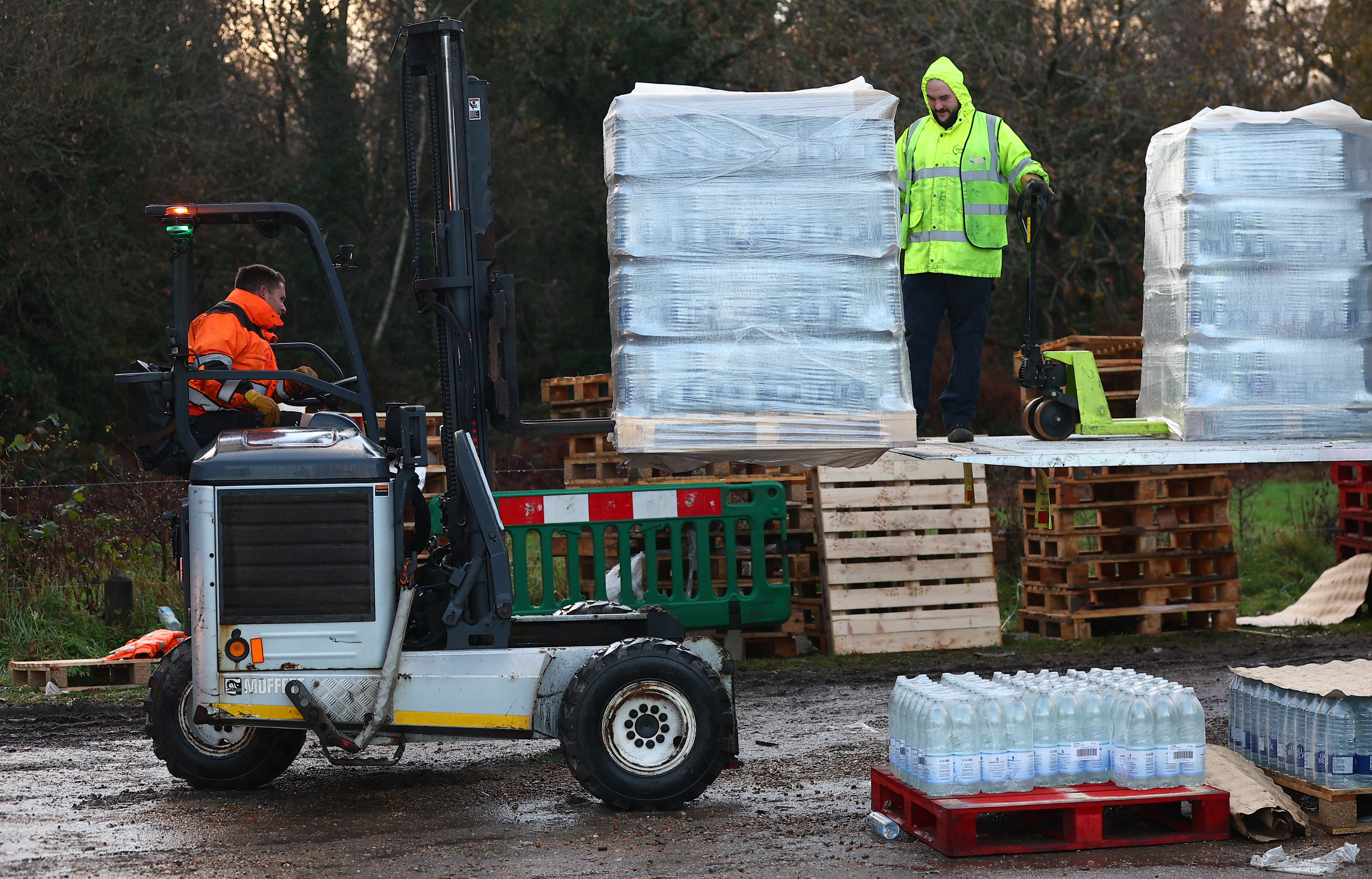 Two volunteers distributing bottled water during a water shortage crisis.