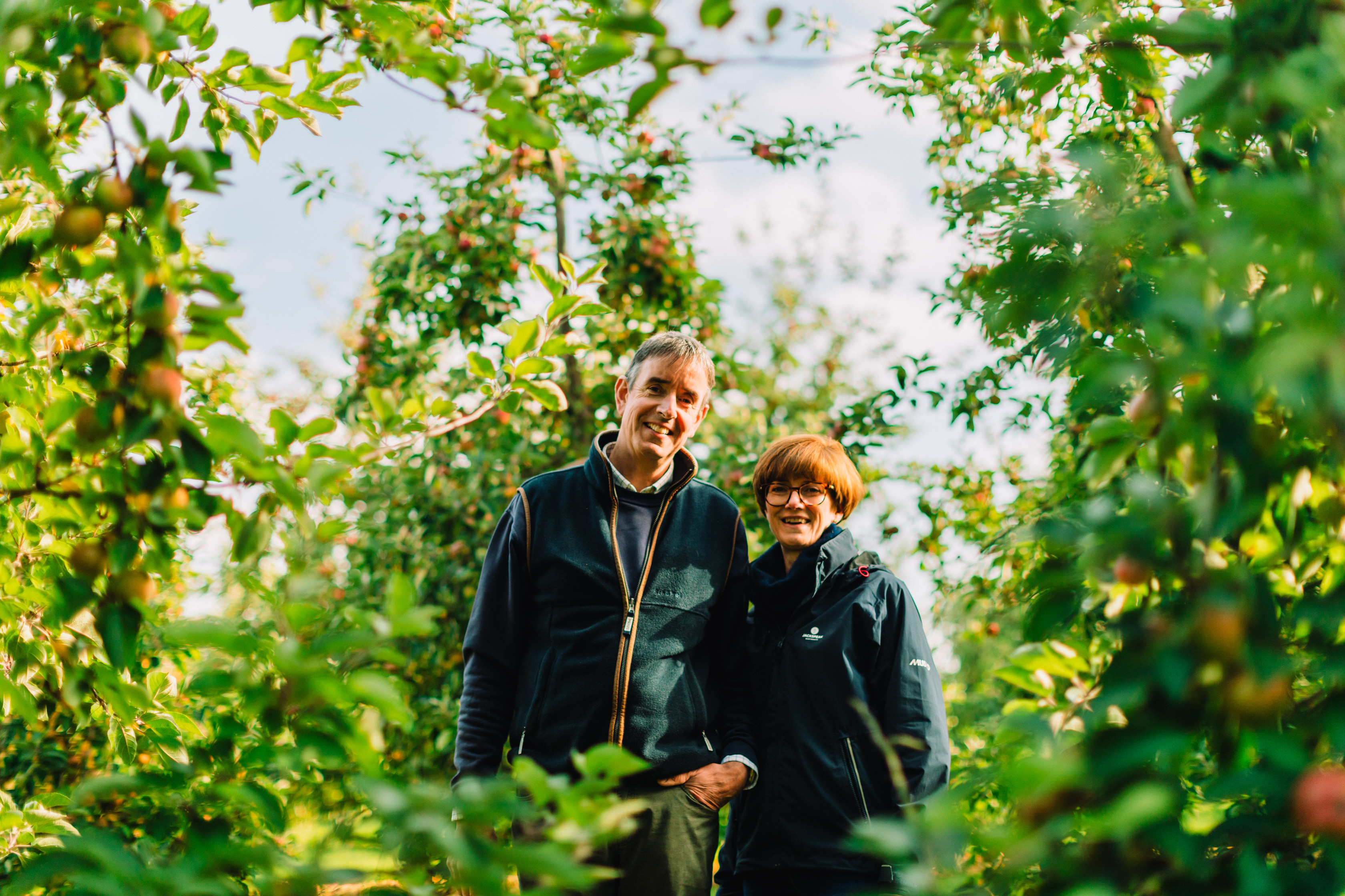 Richard and Ali Capper standing in a field of beer hops.