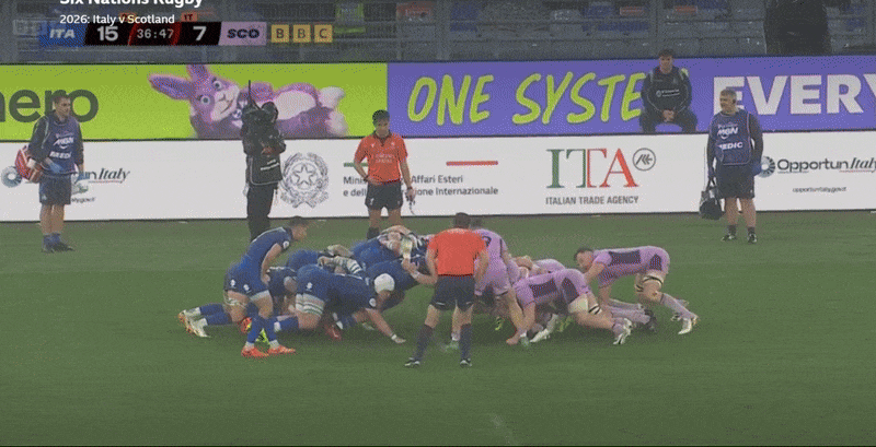 Rugby players from Italy and Scotland forming a scrum during a match.