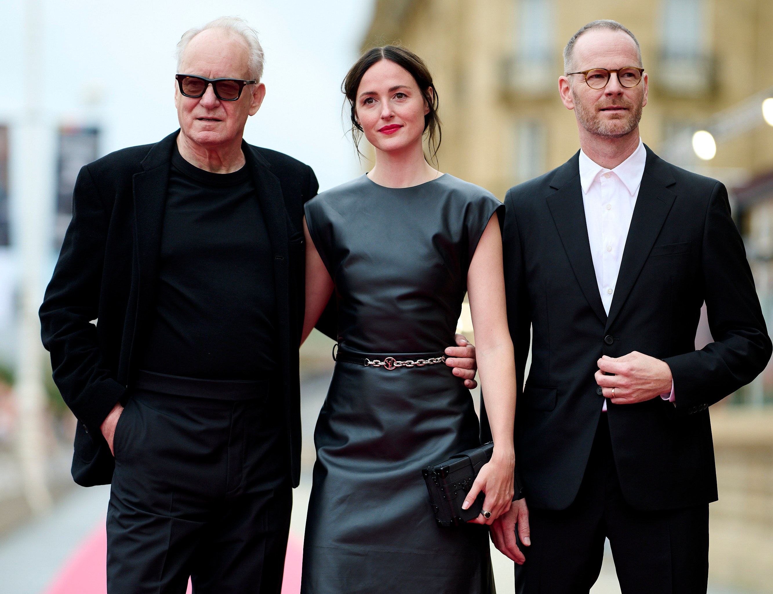 Stellan Skarsgård, Renate Reinsve, and Joachim Trier posing on the red carpet.