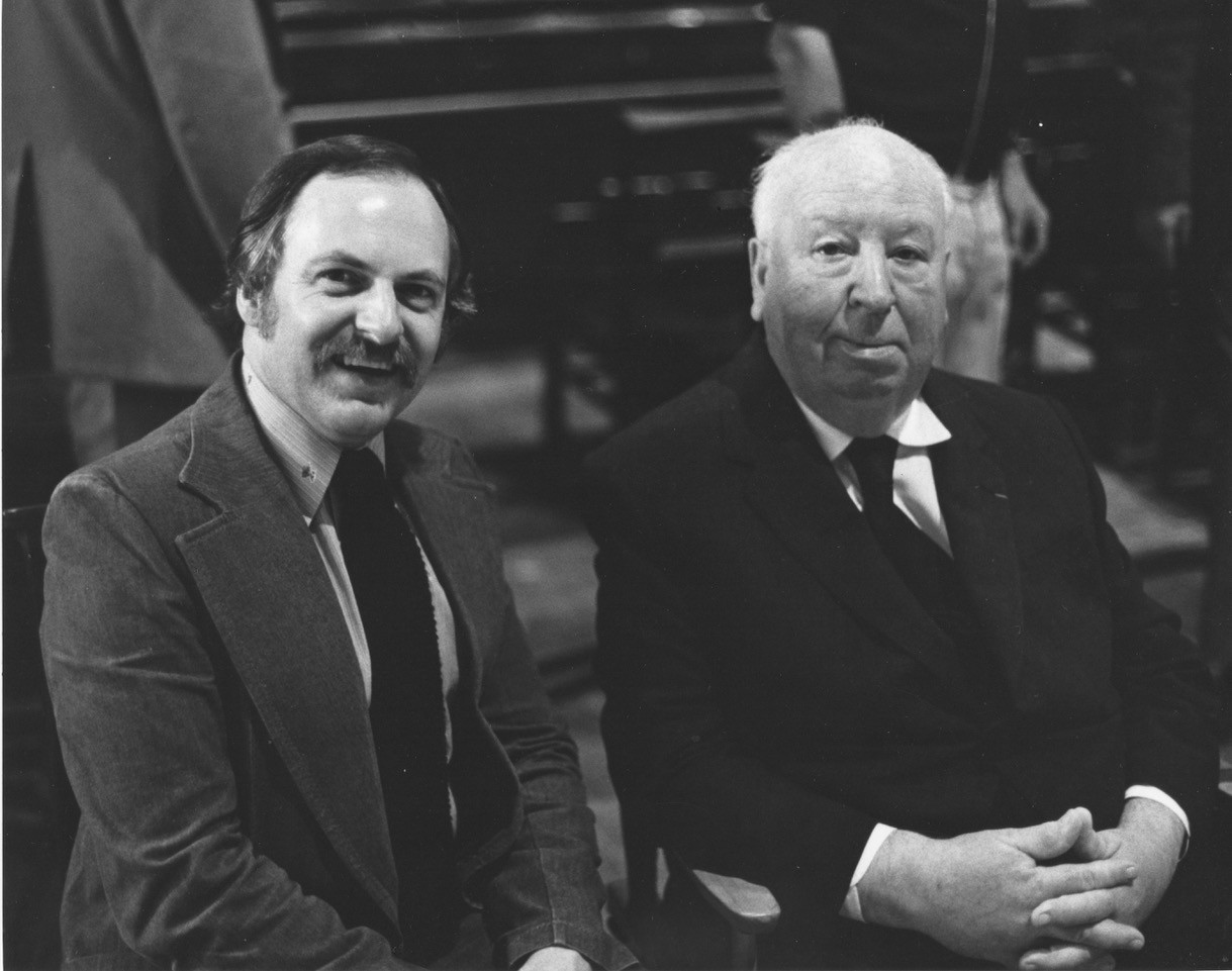 John Russell Taylor and Alfred Hitchcock seated together.