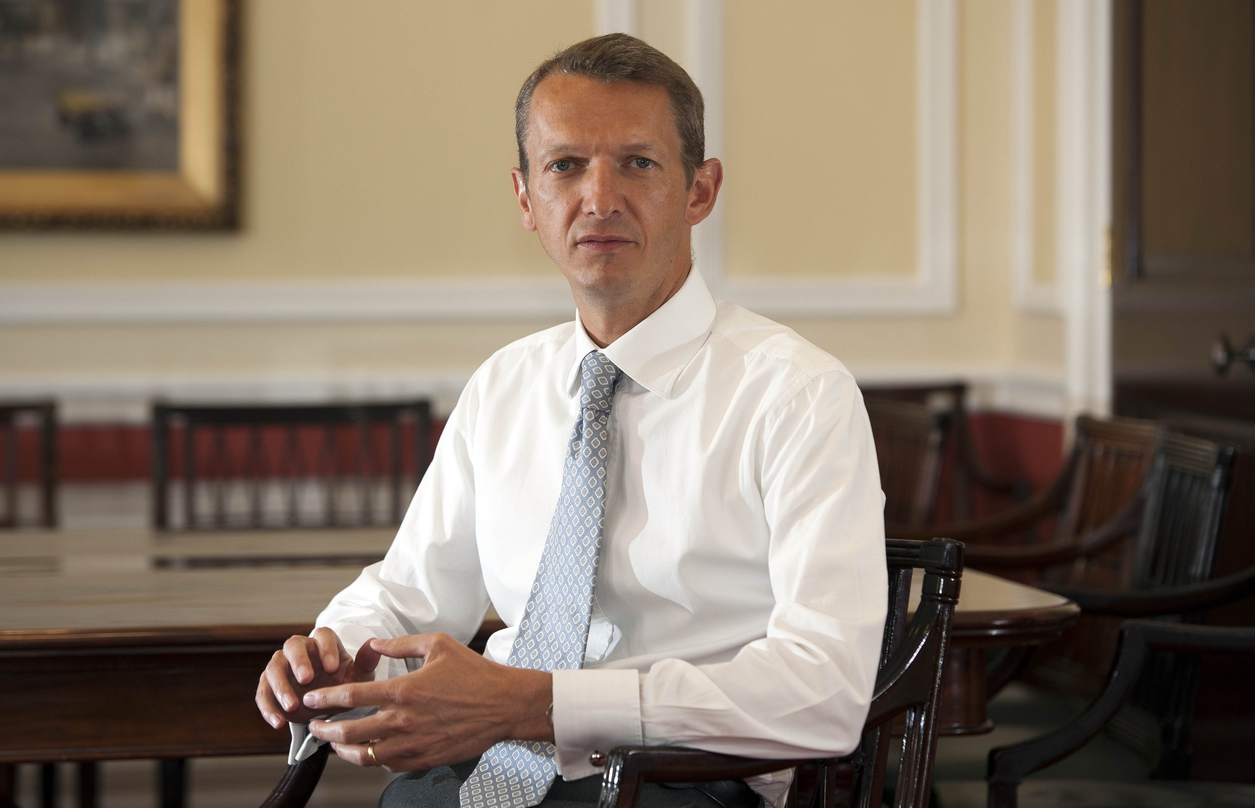 Andy Haldane, Executive Director for Financial Stability at the Bank of England, sits at a wooden table in a white shirt and patterned blue tie.
