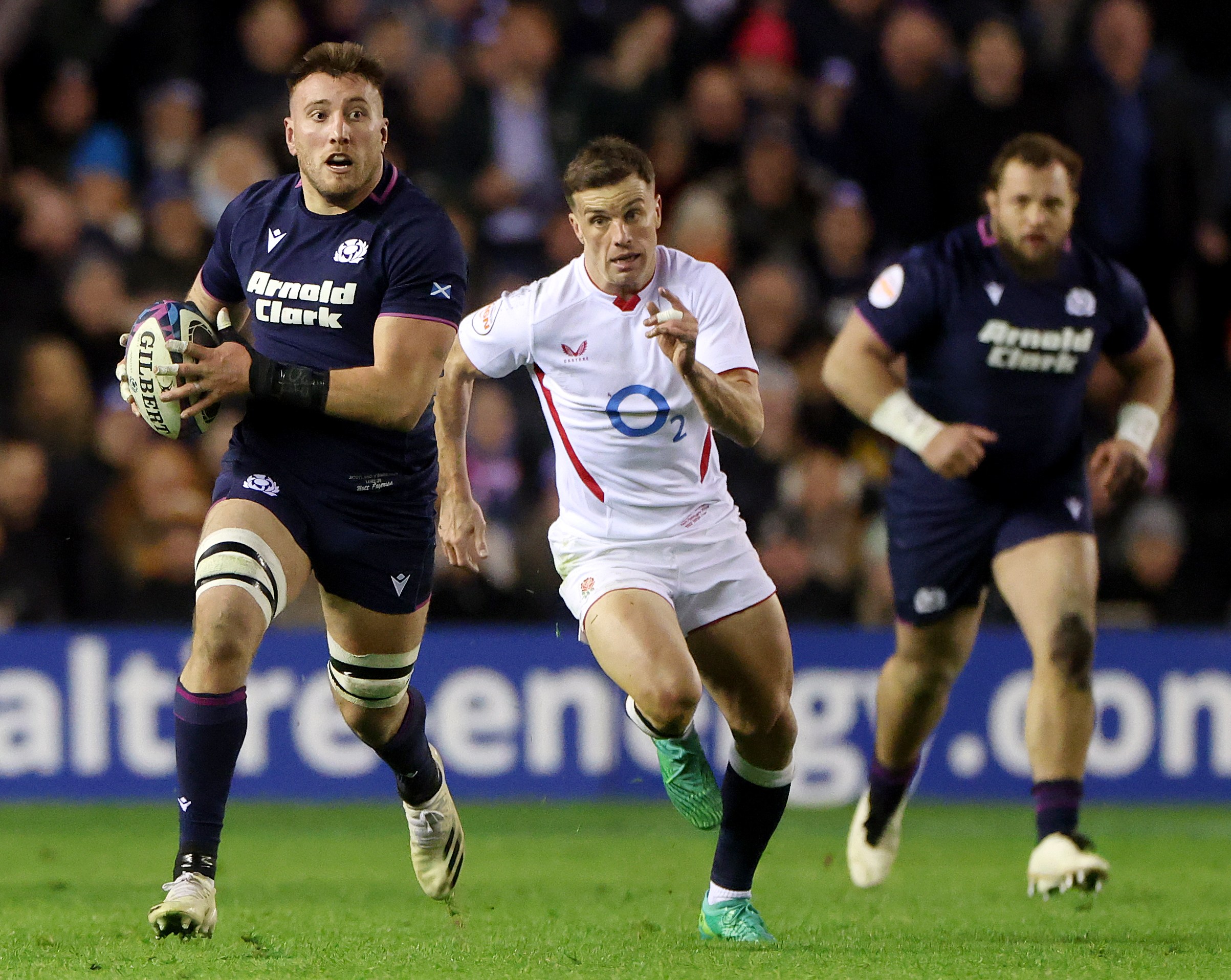 Matt Fagerson of Scotland runs with the ball, breaking away from George Ford of England during a rugby match.