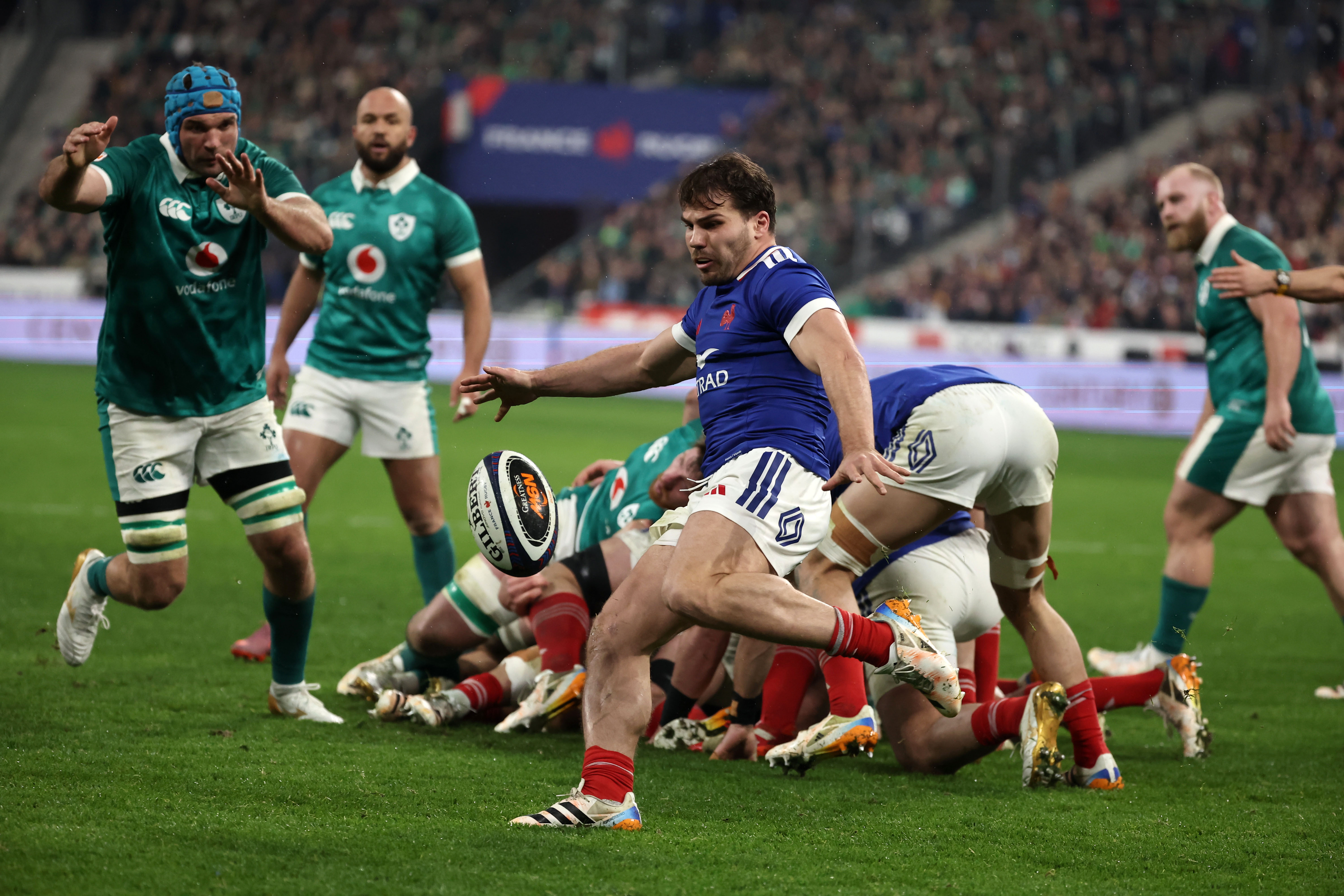 Antoine Dupont of France kicking the ball during a rugby match against Ireland.