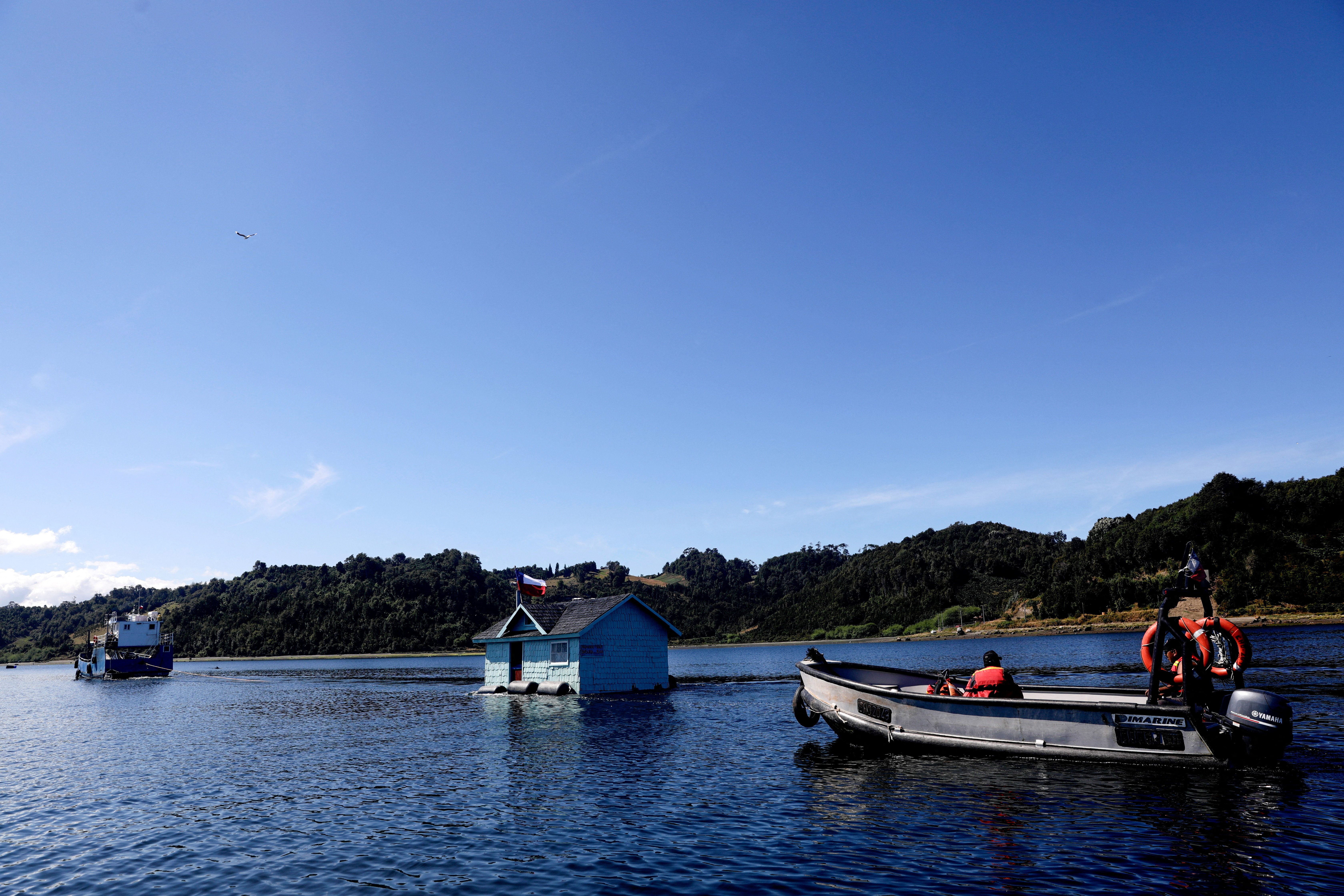 People take part in a local tradition of moving houses between islands, at Lemuy island