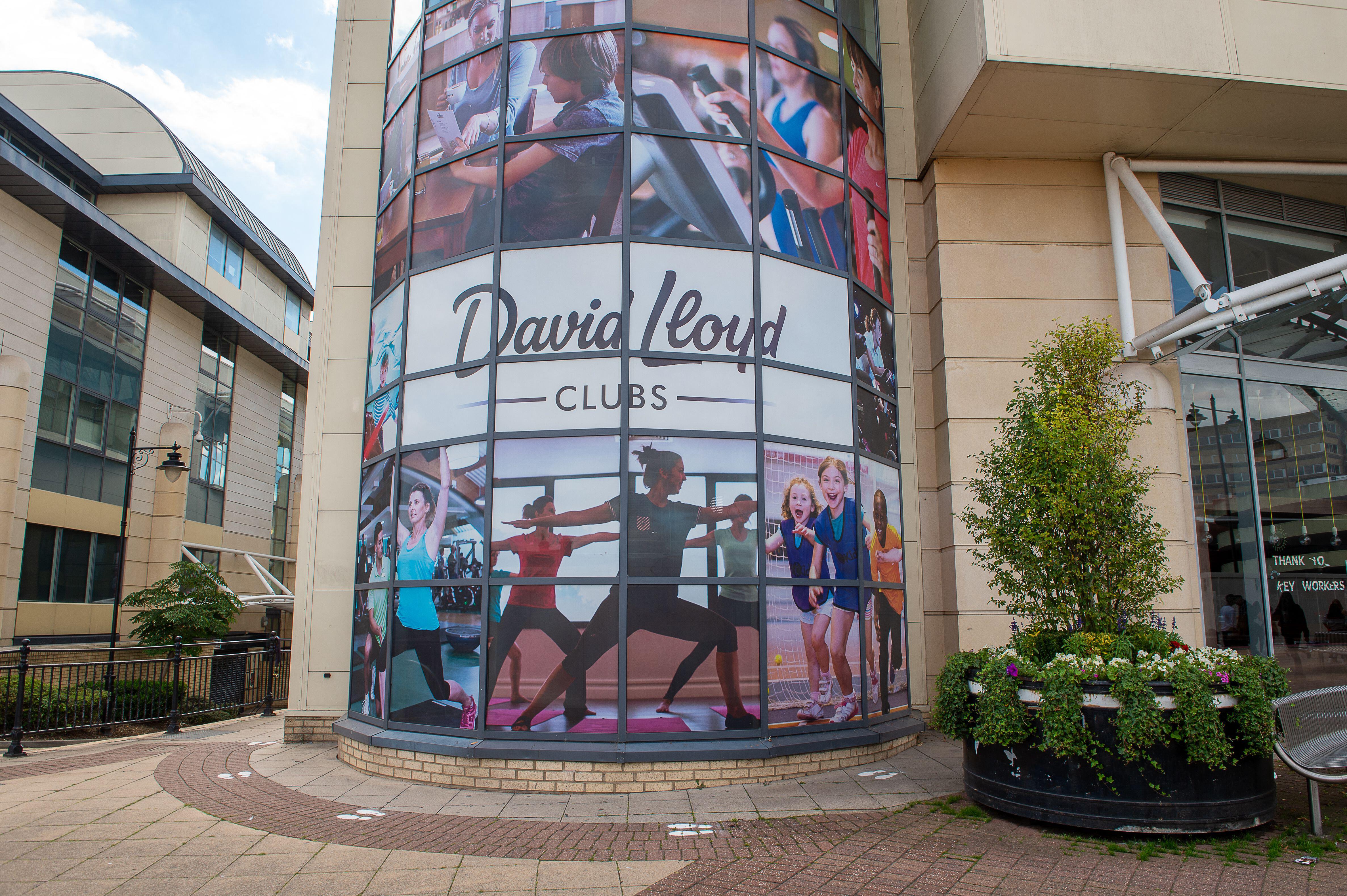 Exterior of David Lloyd Club in Maidenhead, UK, with large advertisements on the windows and a sign thanking key workers.