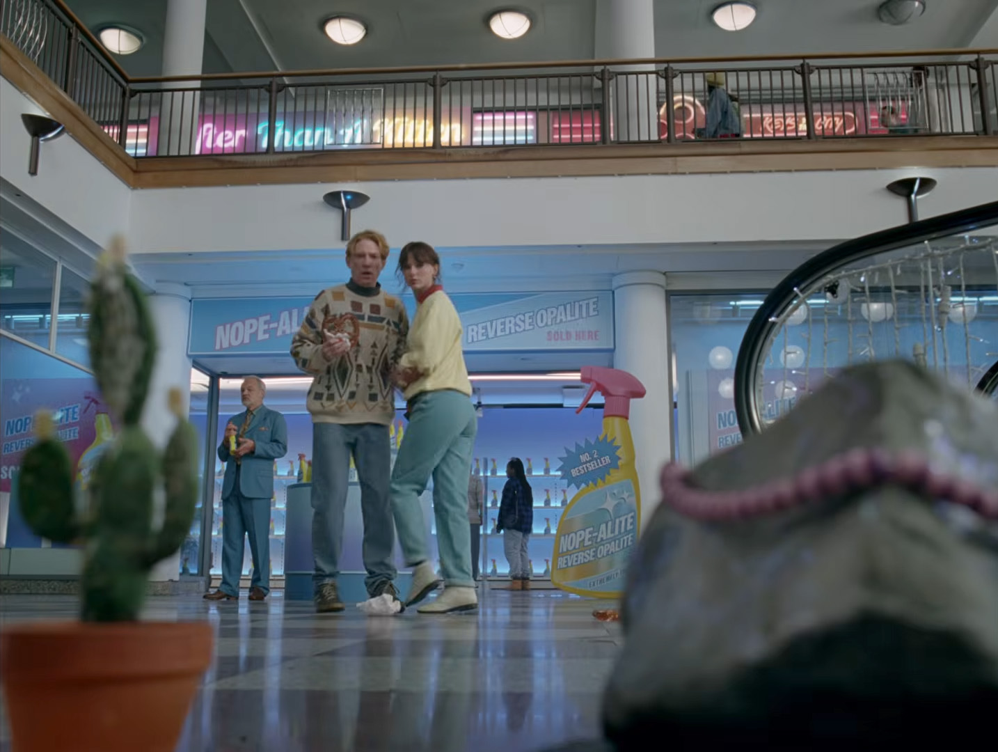 A scene from Taylor Swift's "Opalite" music video, featuring Domhnall Gleeson and Laura Whitmore in The Whitgift Centre.