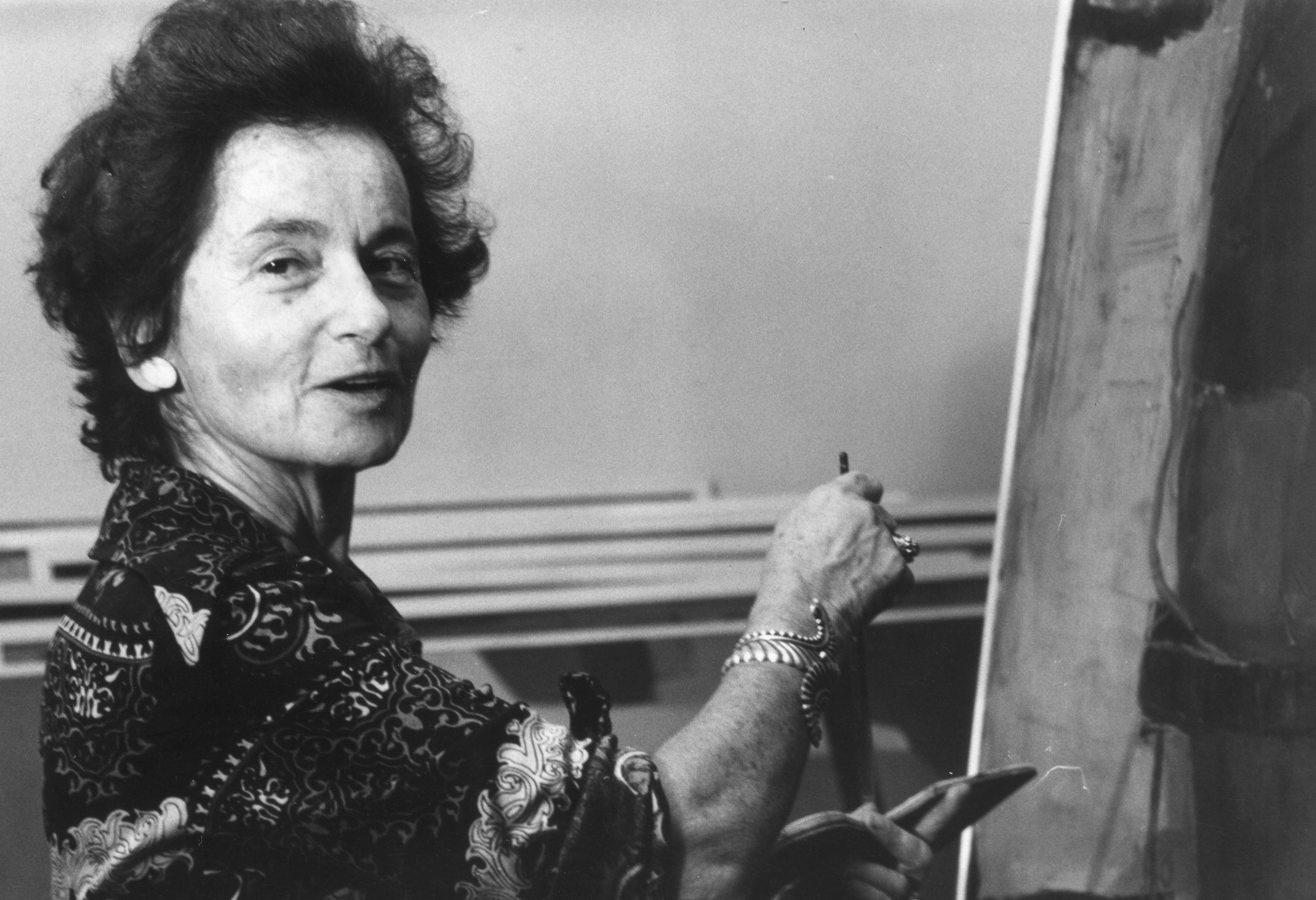 Suzanne Perlman painting at an easel.