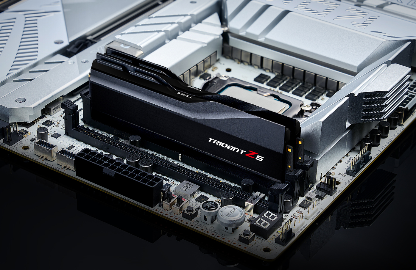 A close-up view of a G.Skill Trident Z5 RAM module installed on a high-end computer motherboard with metallic heatsinks.