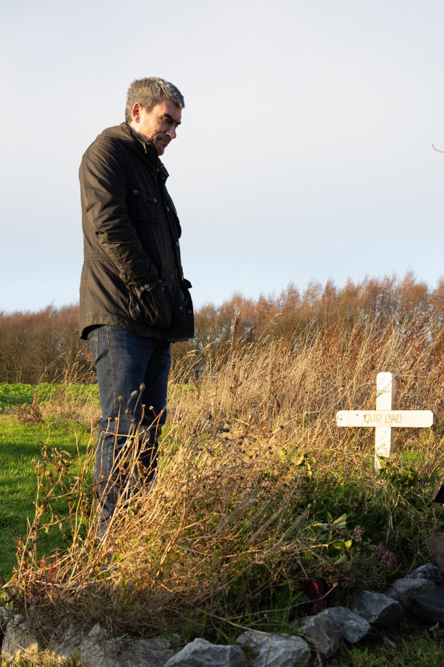 Cain stands by Zak's grave in Emmerdale