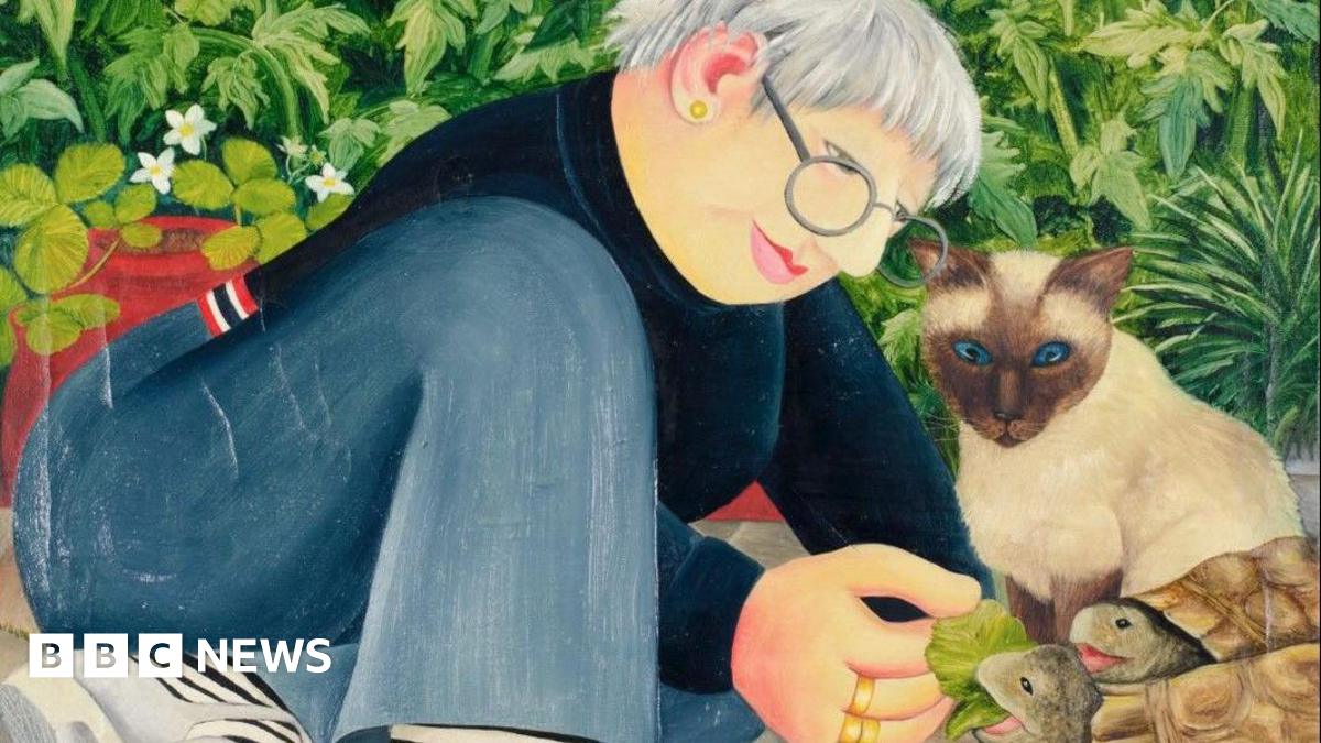 Artist Jo Beer is pictured in front of a self-portrait on the wall behind her.