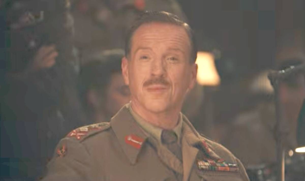 A man in a military uniform smirks