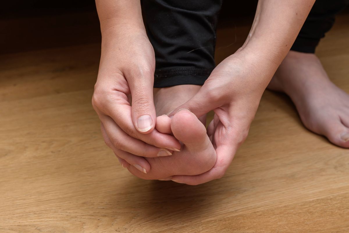 A woman touches and examines her footcloseup