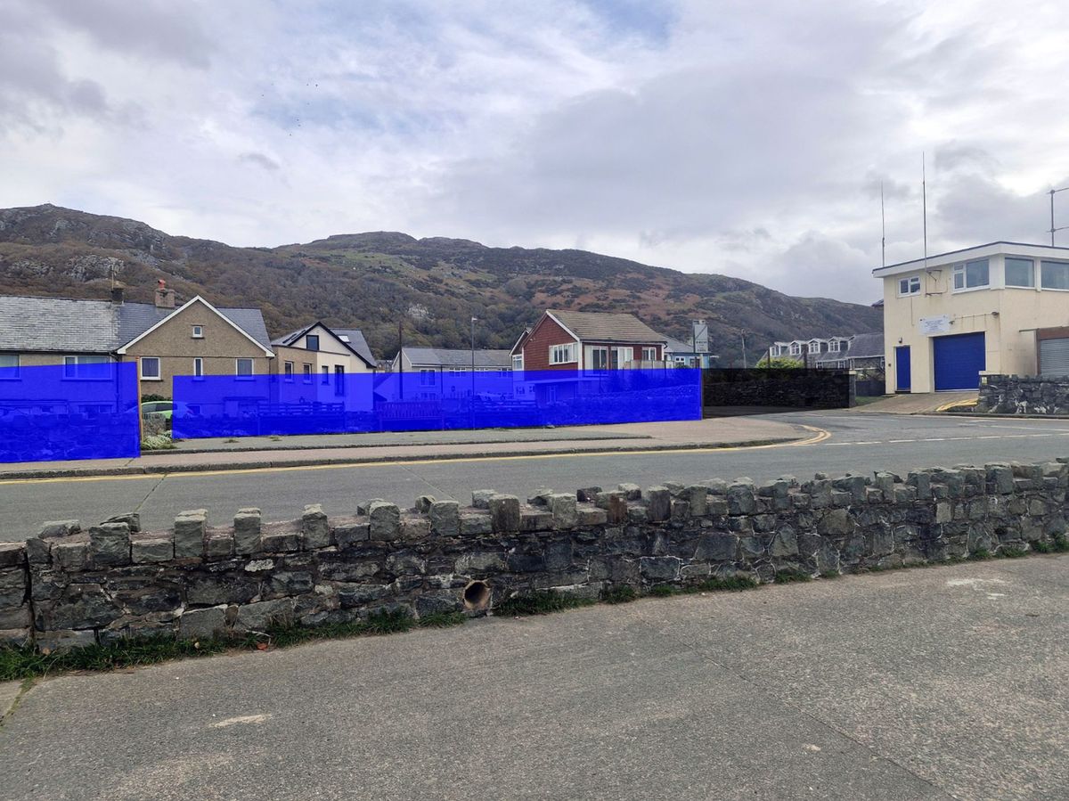 Using wooden planks, Kye  produced a 'very close-to-accurate' visual of the impact of the planned 1700mm (5.5ft) secondary wall (blue) viewed from the promenade. Also shown is a 1700mm (5.5ft) flood gate (black) planned at Barmouth's Coastguard look-out