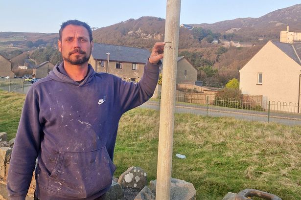 Kye puts a 1700mm mark on a post to give an idea of the height of the planned secondary defence wall