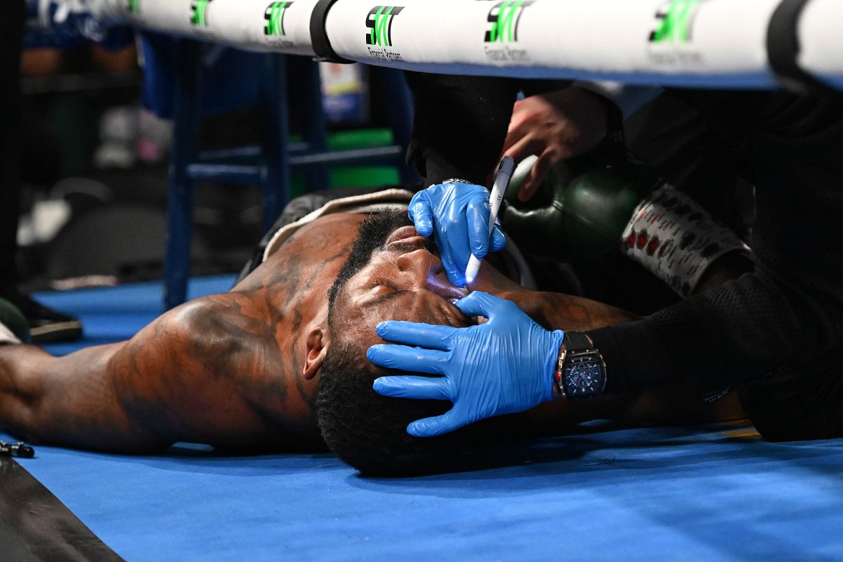 Trainers check on Joe George Jr. after he collapsed in his corner