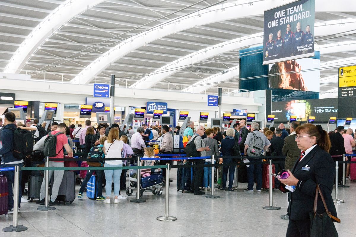 British Airways passengers queue inside Heathrow airport Terminal 5