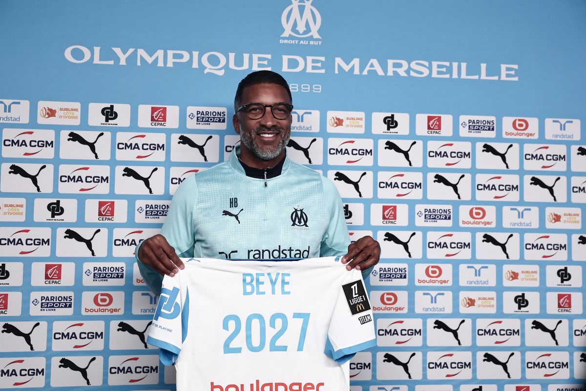 Marseille's football team newly appointed head coach French-Senegalese Habib Beye poses with a team jersey at the end of a press conference following his first training session at Olympique de Marseille's Robert-Louis-Dreyfus training camp