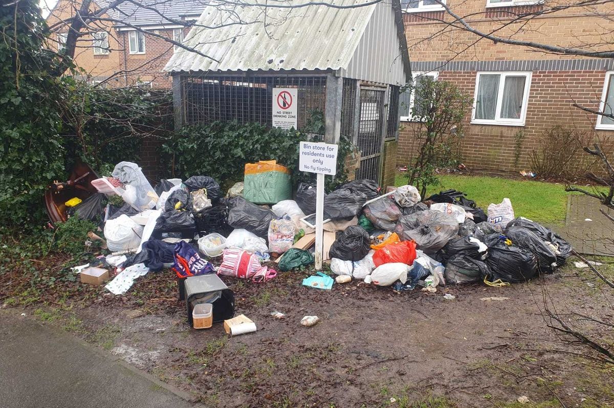 Rubbish dumped outside a metal bin storage building