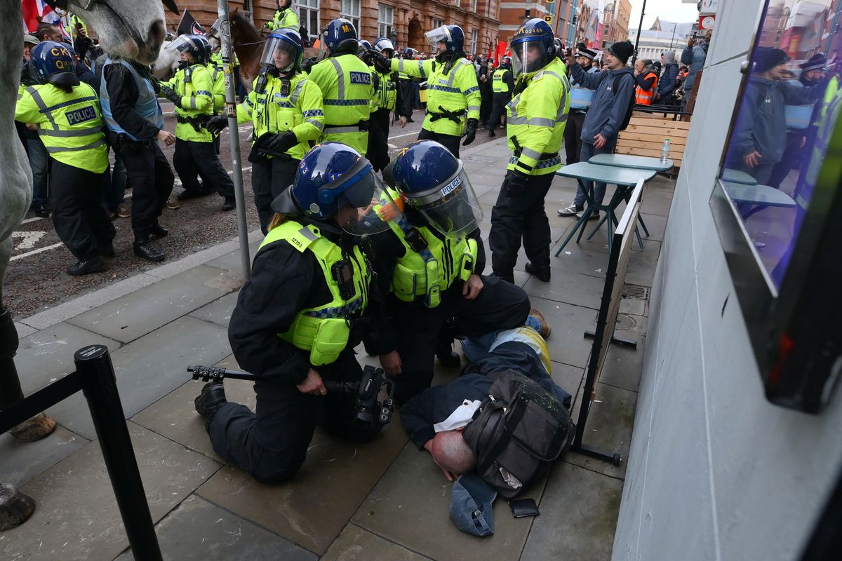 A demonstrator and police amid protests in the city centre