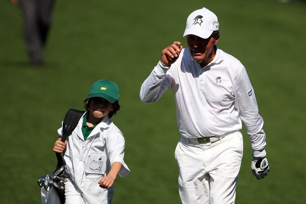 Gary Player and grandson Sebastian walk towards a green at Augusta.