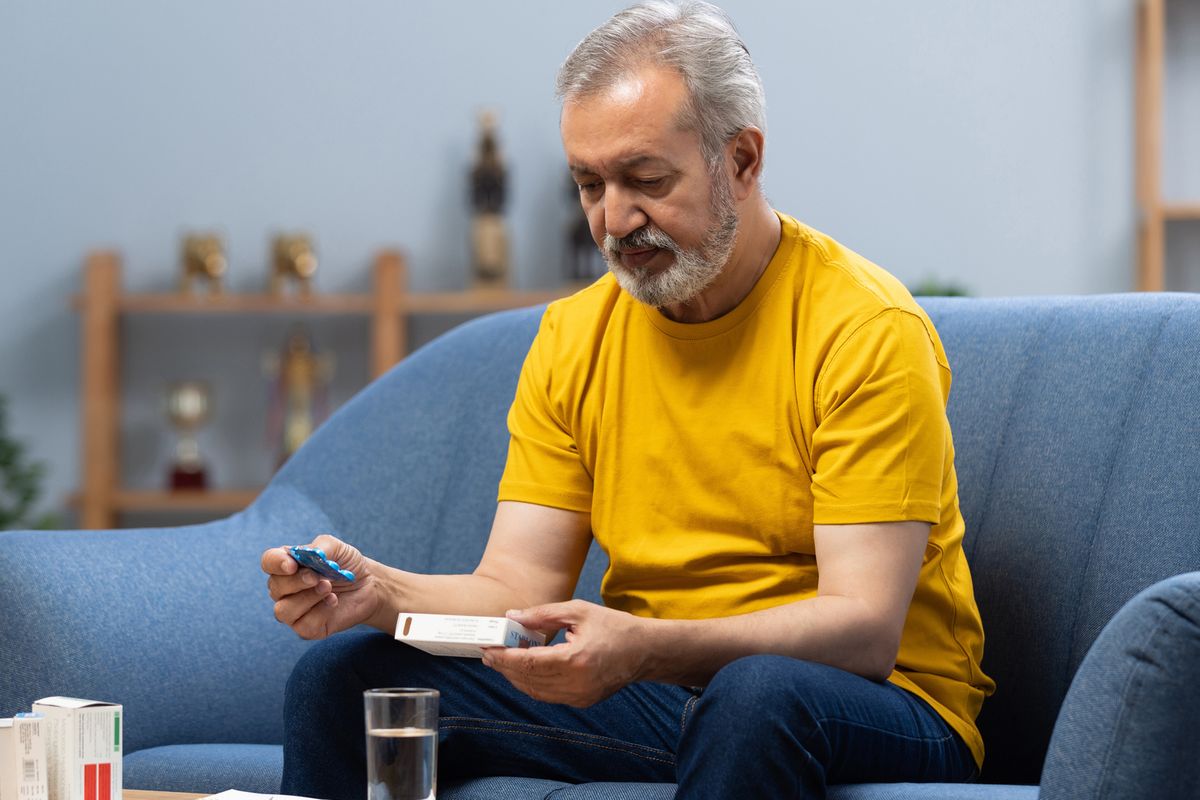 Senior man holds medicine box