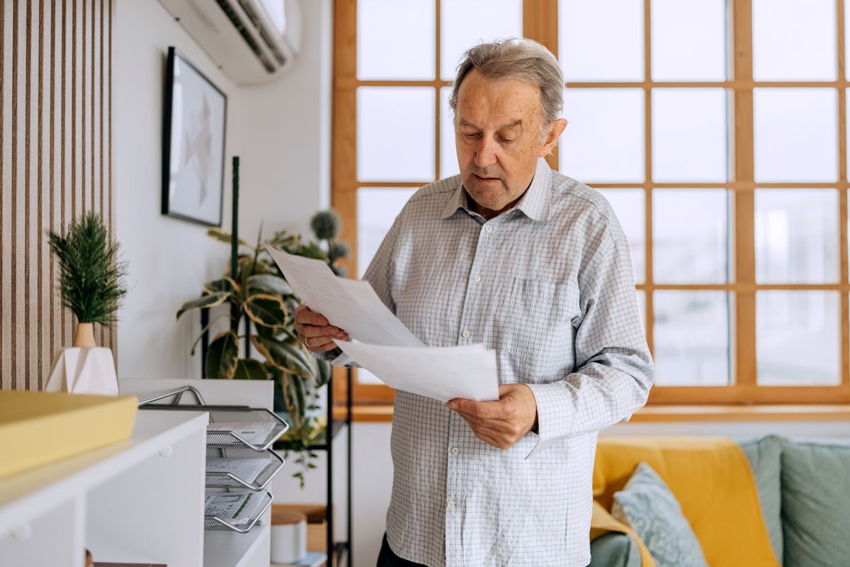 Senior man looking at bills at home