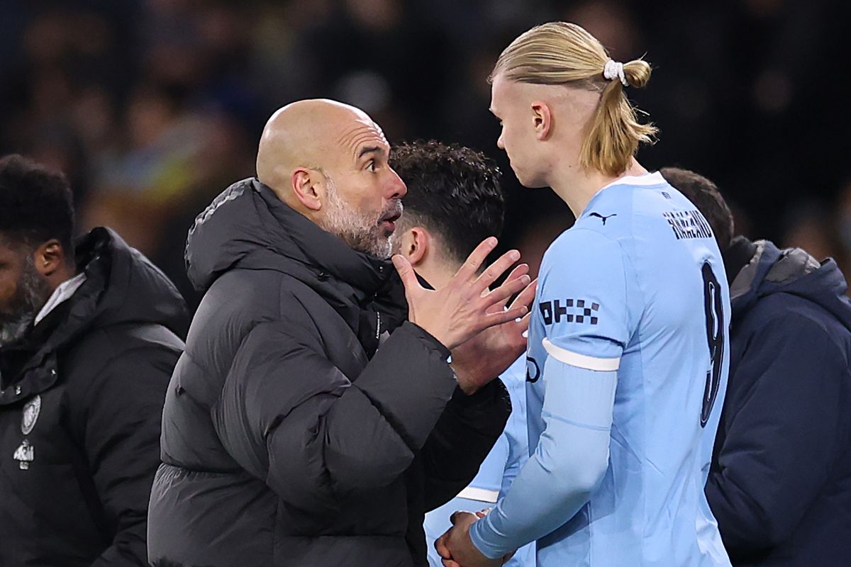 MANCHESTER, ENGLAND - FEBRUARY 04: Pep Guardiola, Manager of Manchester City, speaks with his player Erling Haaland ahead of being substituted onto the field during the Carabao Cup Semi Final Second Leg match between Manchester City and Newcastle United at Etihad Stadium on February 04, 2026 in Manchester, England. (Photo by Kate McShane/Getty Images)