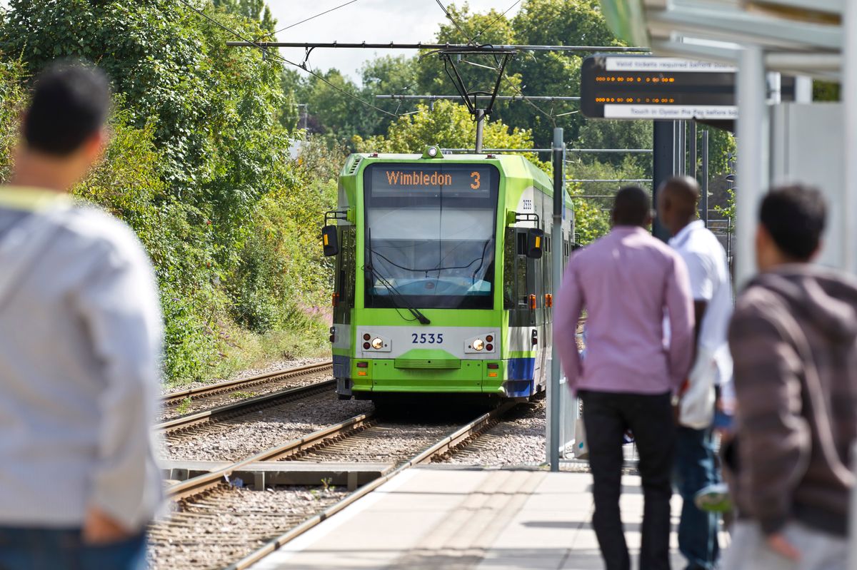 Passengers waiting as a tram pulls into Waddon Marsh tram stop.